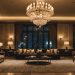 Luxurious hotel lobby with chandelier and plush seating.